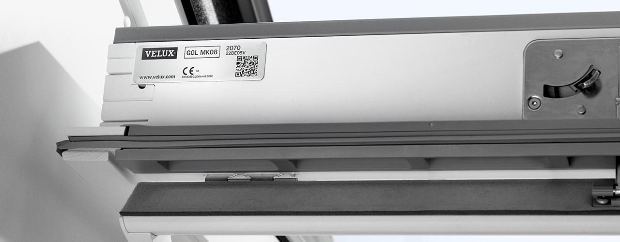Typeplaatje bovenin het kozijn van een VELUX dakraam met type en maatcode
